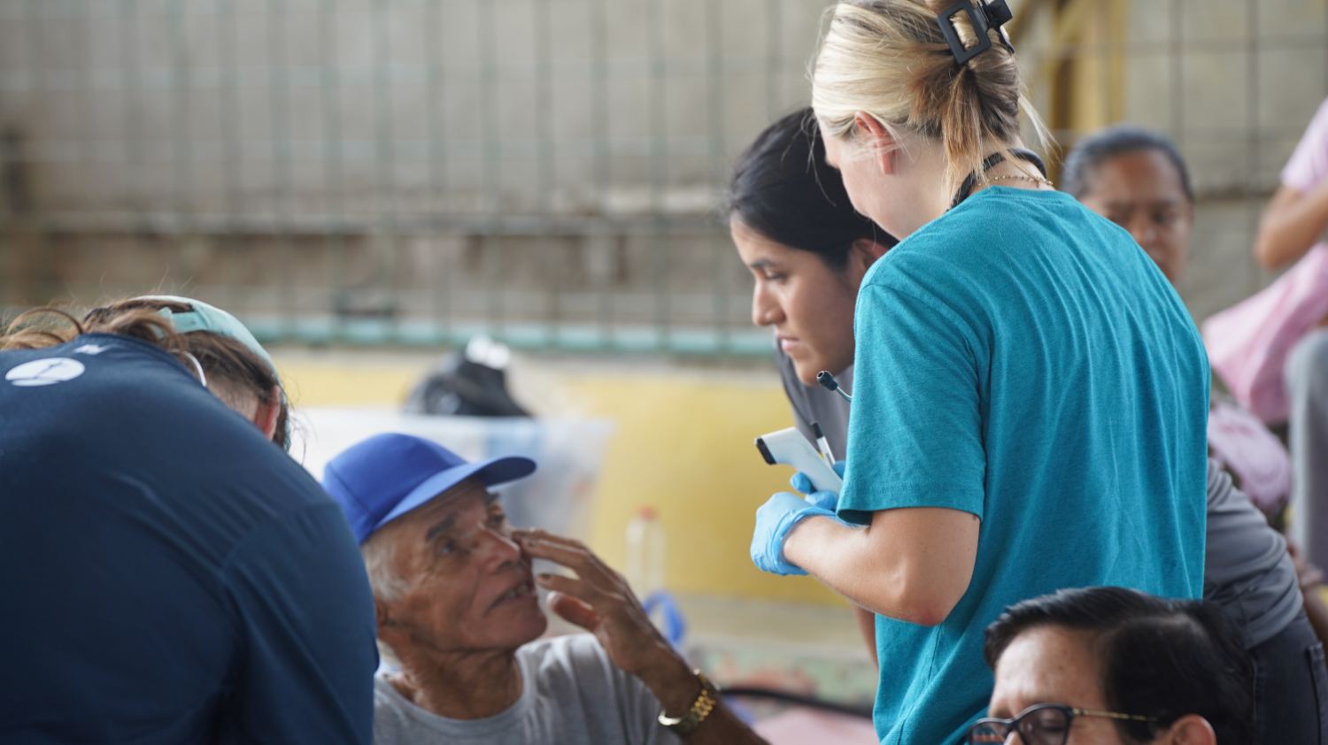 Voluntarias atendiendo a un adulto mayor durante la brigada