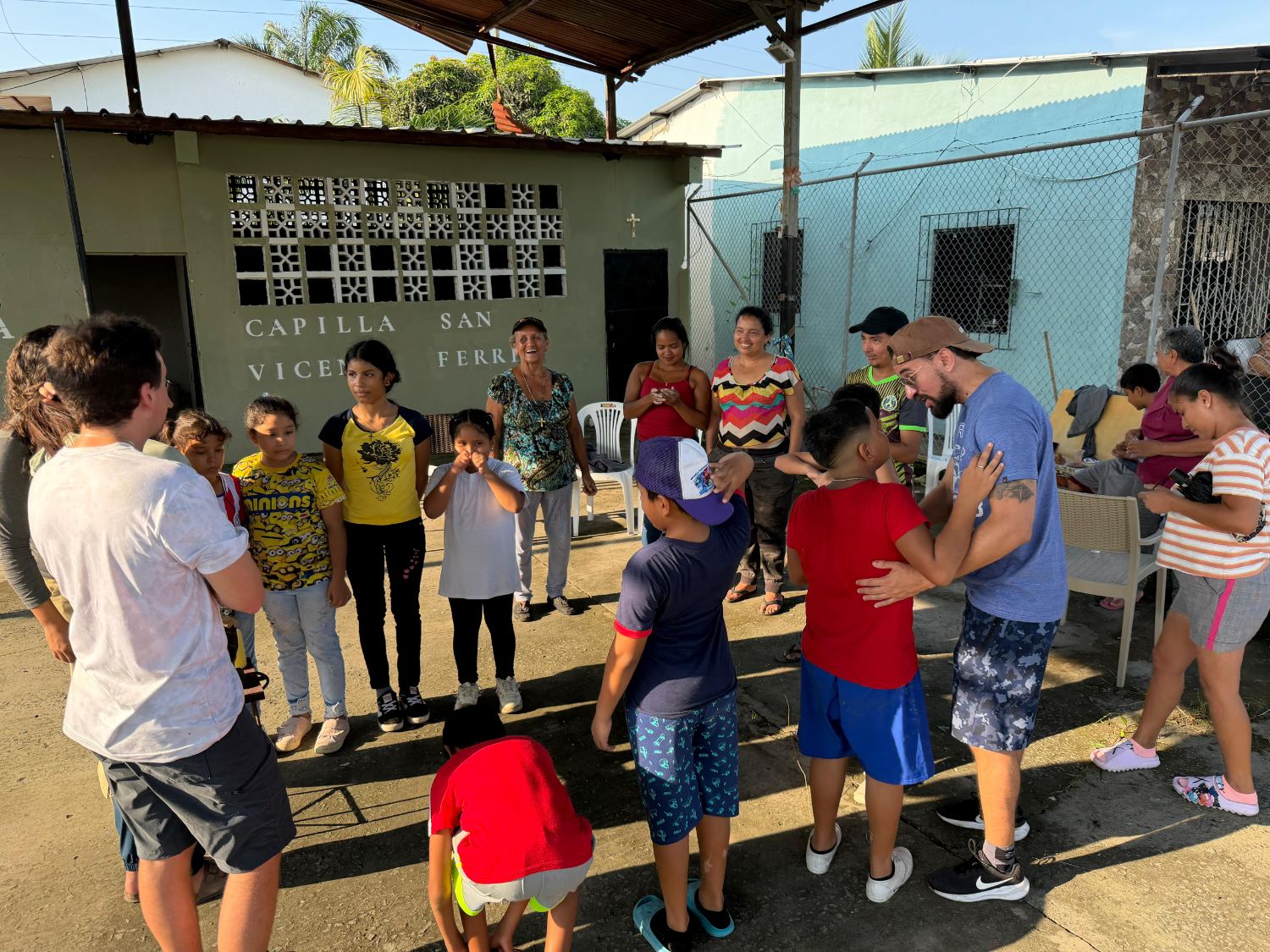 Misioneros y niños de la comunidad jugando frente a la capilla San Vicente Ferrer