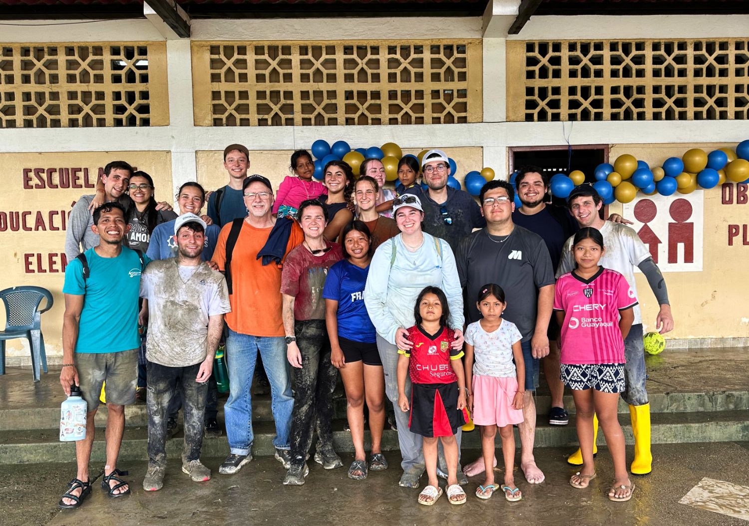 Misioneros y niños de la comunidad frente a la Escuela 7 de Noviembre