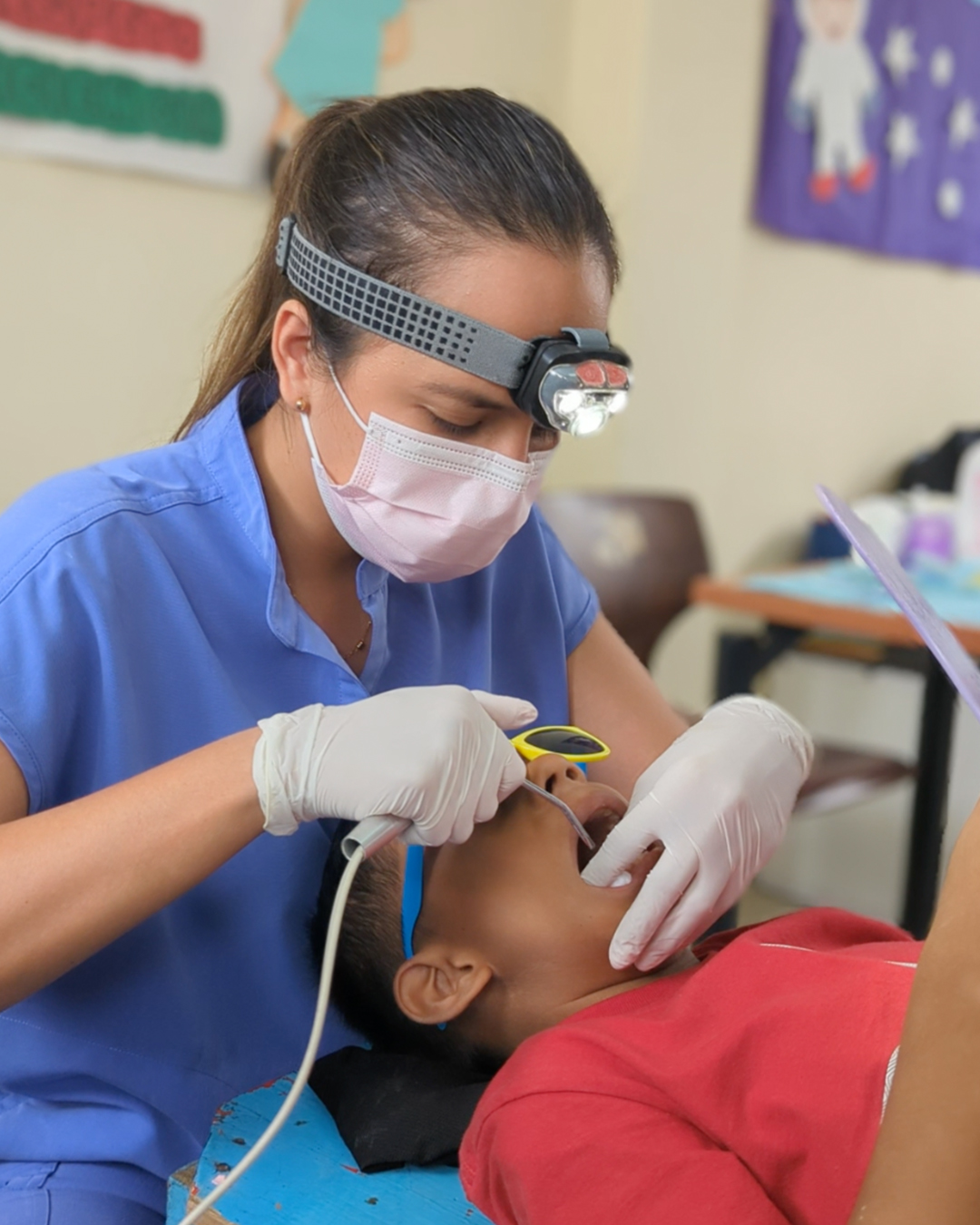 Odontóloga atendiendo a un niño en una brigada médica