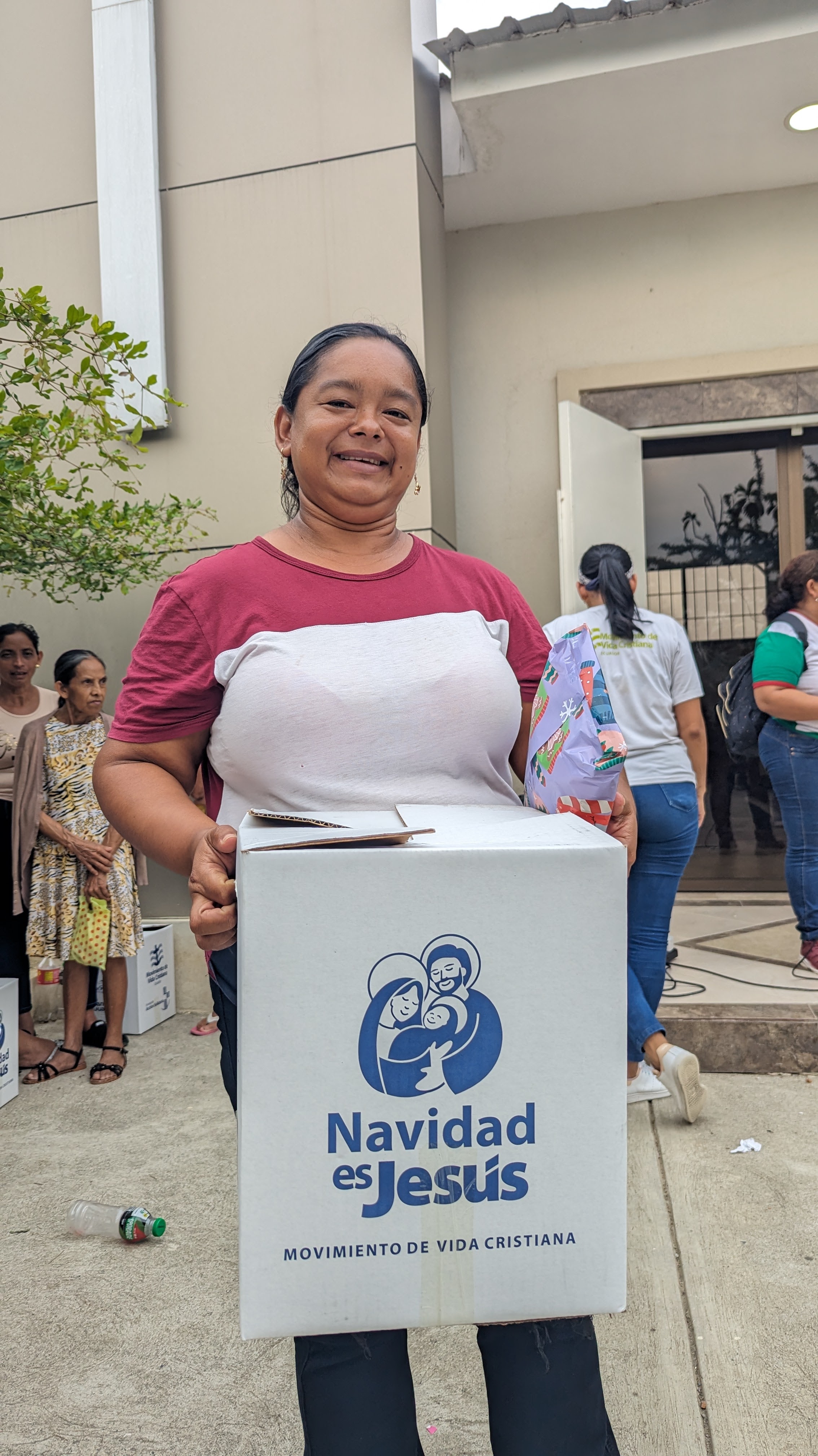 Mujer de la comunidad recibiendo su canasta navideña