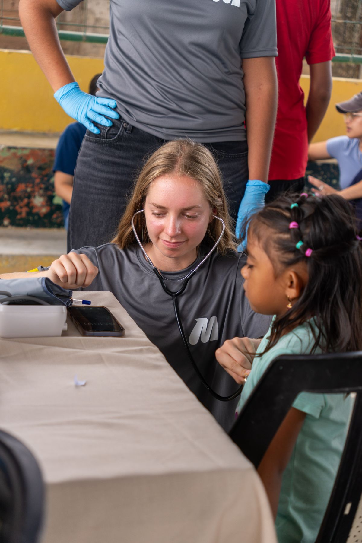 Voluntaria auscultando a una niña de la comunidad